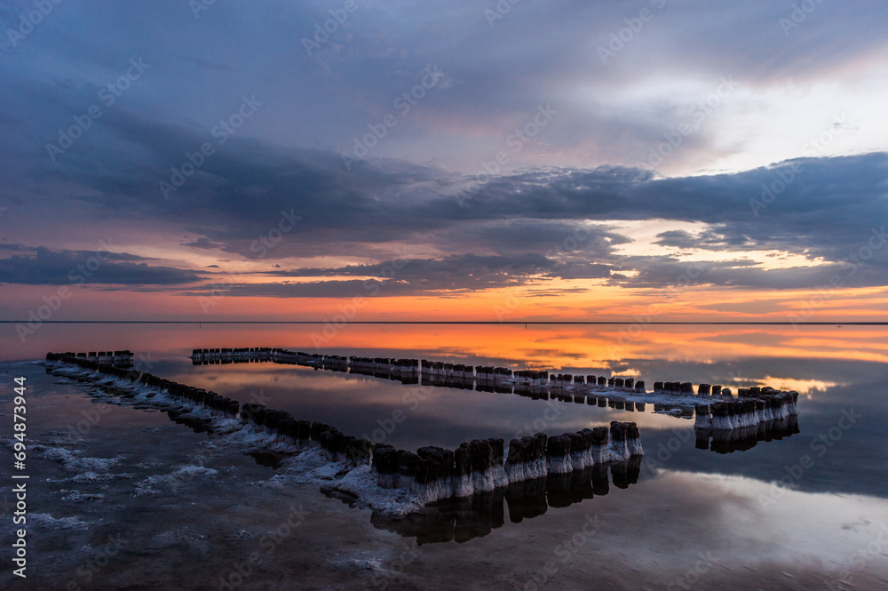 Sunset or sunrise sky clouds over water sunlight. Dramatic nature background.