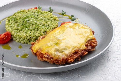 Chicken schnitzel under cheese with pittitimus. Isolated image
