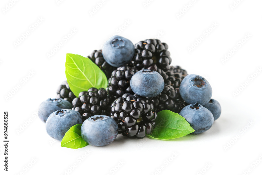 Sweet berries mix with green leaves isolated on white background. Ripe blueberry and blackberry. Sweet berries mix with green leaves isolated on white background. Ripe blueberry and blackberry.