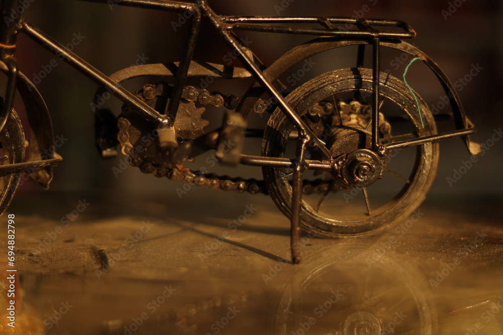 Fototapeta premium A Vintage Black Indian Iron Bicycle or cycle toy standing on a dirty glass with selective focus, closeup shot
