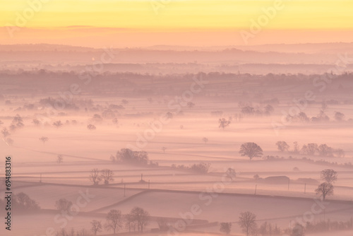 Dawn over the mist shrouded countryside of the Somerset Levels in winter, Glastonbury, Somerset, England, United Kingdom, Europe photo