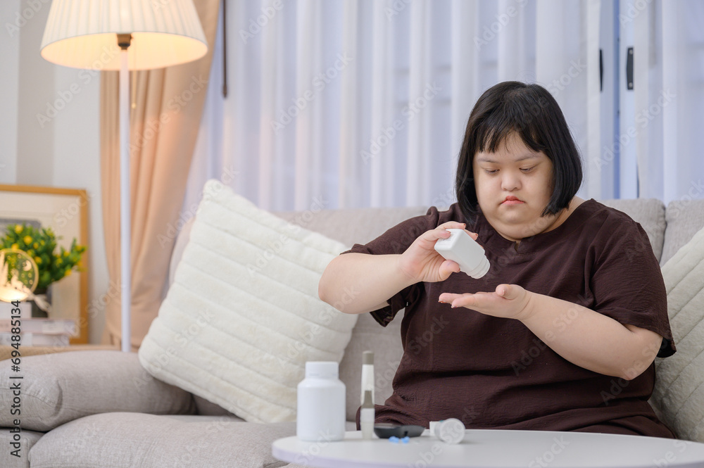 Fat woman or Asian teenage girl disabled with Down syndrome A diabetic patient is taking diabetes medicine at home Fat woman or Asian teenage girl disabled with Down syndrome A diabetic patient is taking diabetes medicine at home