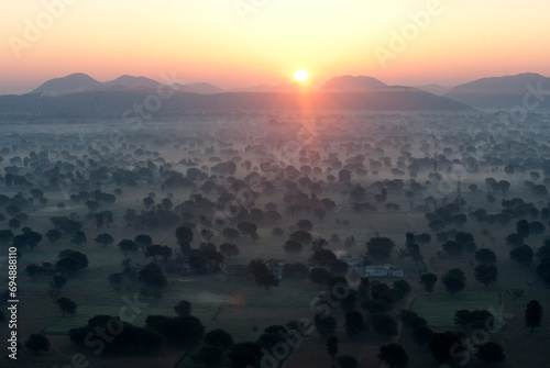 Sun rising over the hills and countryside surrounding Samode, from hot air balloon, Rajasthan, India photo