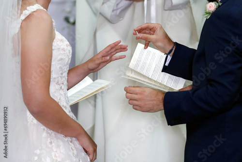 Wedding ceremony in a Catholic church, wedding rings being exchanged photo