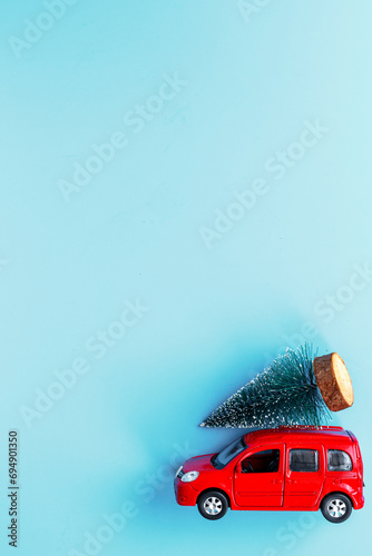 Fototapeta Naklejka Na Ścianę i Meble -  Festive New Year decoration and red toy car with Christmas tree on the roof