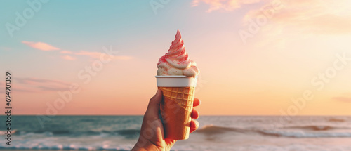 A hand holding a paper cup with a melting ice cream cone, evoking memories of childhood summers spent playing on the beach. The image could be nostalgic and sentimental