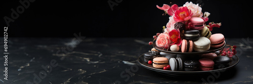 Valentines Day Macaron Tower Topped with Edible Blossoms on a Shiny Obsidian Base, Featuring Shades of Champagne Pink and Deep Black photo