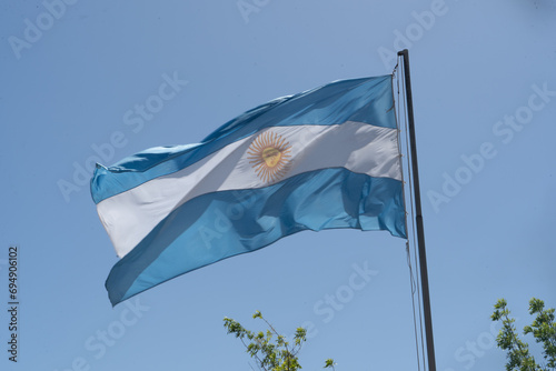Argentine flag flying in a blue sky