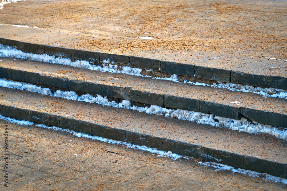 Sand sprinkled on stairs to prevent slipping on slick steps. Spread