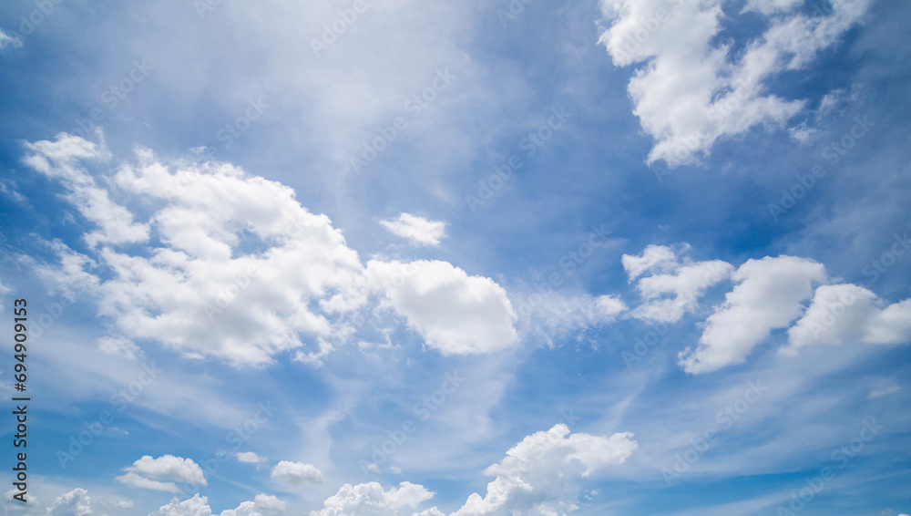 Obraz premium Panoramic view of clear blue sky and clouds, Blue sky background with tiny clouds. White fluffy clouds in the blue sky. Captivating stock photo featuring the mesmerizing beauty of the sky and clouds.