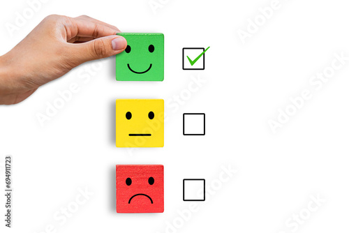 hand holding emotion face symbol on Green, yellow and red wooden blocks, Consumers Show Satisfaction Rating concept by evaluating business success. Services and products and Customer Engagement. photo