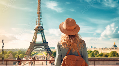 A woman in a hat looks at the Eiffel Tower. Selective focus.