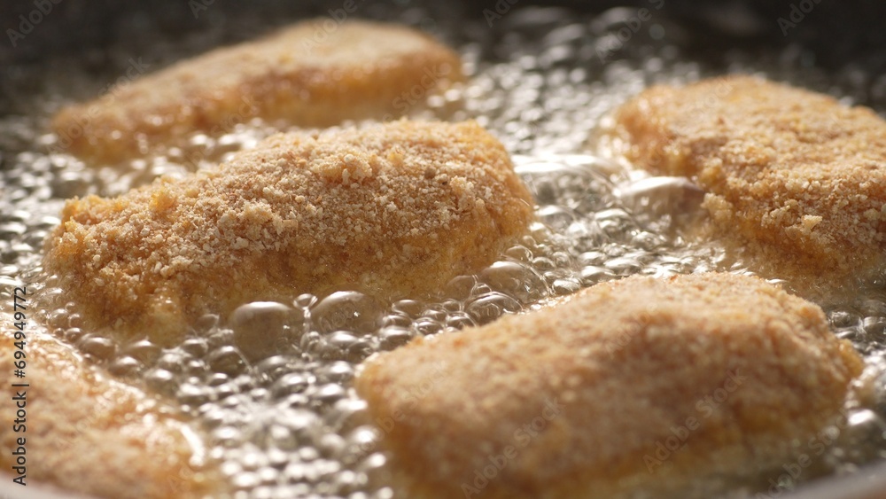 Close-up of Frying Breaded Kievsky Cutlets in Sizzling Oil. Pull out shot, shallow dof.