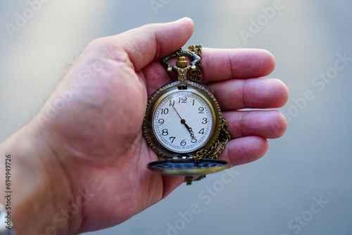 Close up hand holding gold pocket watch, blurred copy space background, saving and manage time to success business, relaxation and lifestyle concept