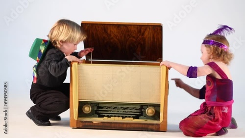 children sitting on the floor and play with old radiogramophone photo