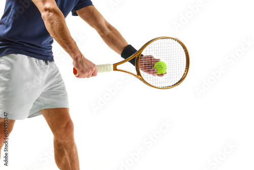 Cropped image of male tennis player in blue shirt and white shorts, serving ball with racket isolated over white background. Concept of professional sport, competition, game, math, hobby, action © master1305
