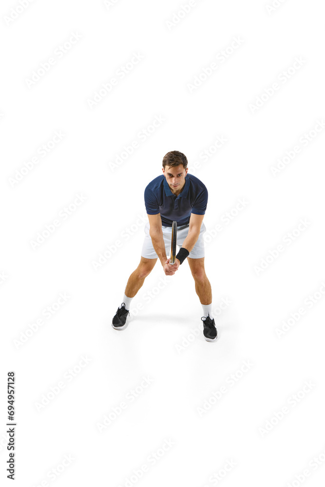 Top view. Concentrated man in his 30s, tennis athlete in motion during game,. practicing isolated over white background. Concept of professional sport, competition, game, math, hobby, action