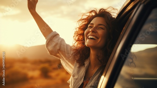 Happy woman stretches her arms while sticking out car window. Lifestyle, travel, tourism, nature, car, person, travel, females, summer, happy photo