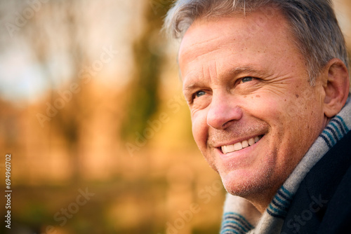 Close Up Of Smiling Senior Man On Walk Through Autumn Park Or Countryside