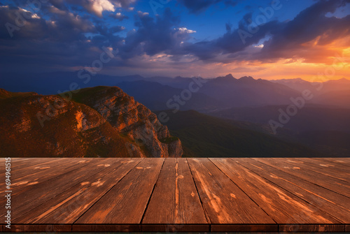 Beautiful sunrise over mountains and empty wooden table in nature outdoor. Natural template landscape