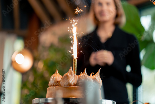 close-up of delicious appetizing cake with lit candle during birthday celebration in restaurant