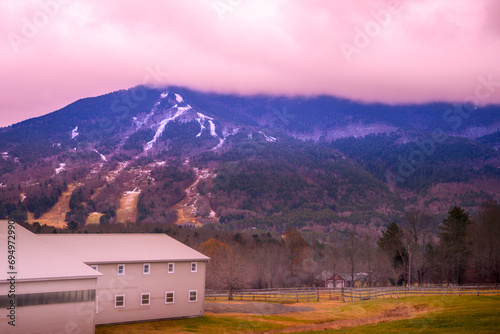 Mount Ascutney Summit and ski slopes and trails over the meadow at foggy moody wintry sunrise in Windsor, Vermont, USA photo