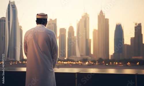 An middle eastern arabian business person looking out over a modern city skyline photo