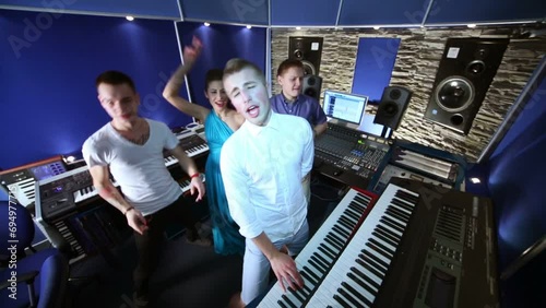 Musical group dance and sing in recording studio photo