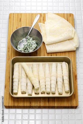 making Sigara borek, Cigar-like Turkish spring rolls.
A dough sheet called yufka wrapped with cheese filling and fried. photo