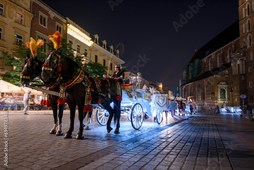 Horse carriages at night in main square in Krakow