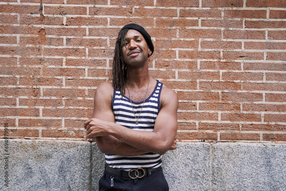 portrait of a young African man in a tank top with his arms crossed, looking at the camera. portrait of a young African man in a tank top with his arms crossed, looking at the camera.