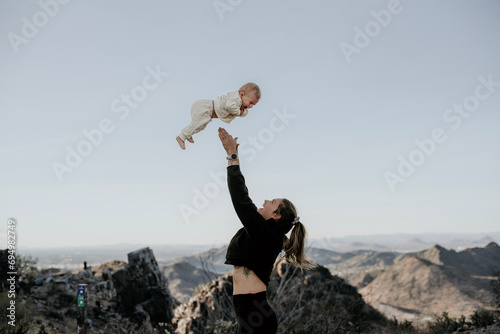 Mom throwing baby up in the sky. Family playing outside