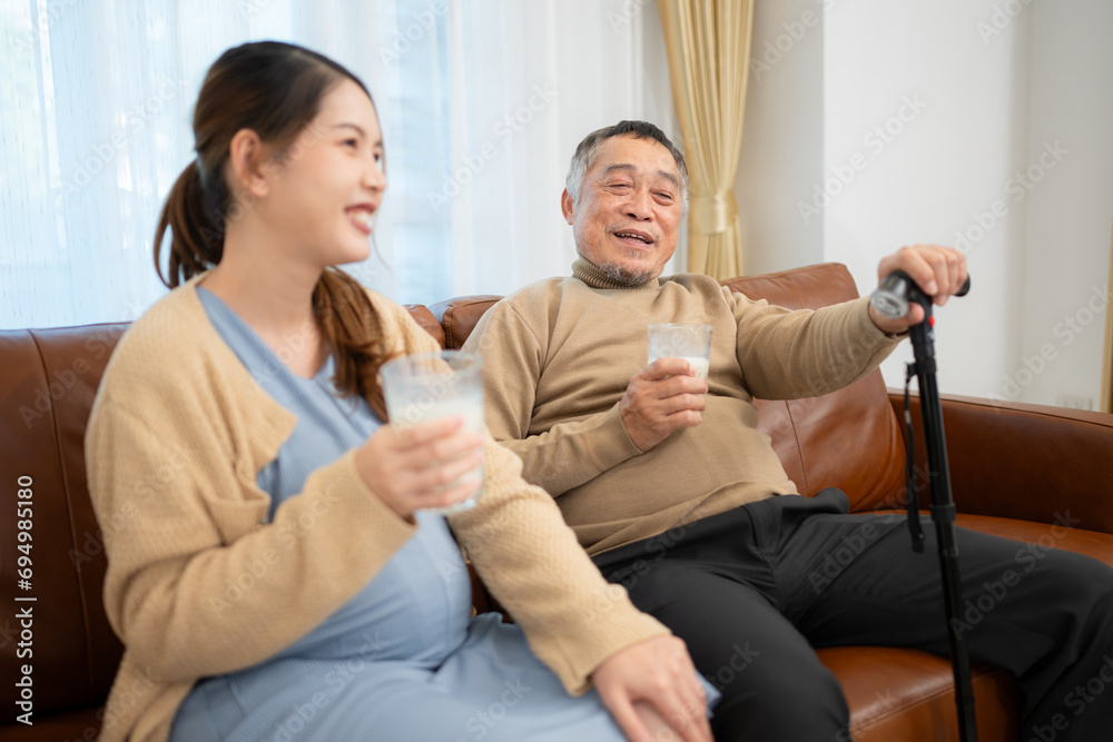 A happy family sits on the sofa in the living room, Father and daughter are pregnant talking to each other. A happy family sits on the sofa in the living room, Father and daughter are pregnant talking to each other.