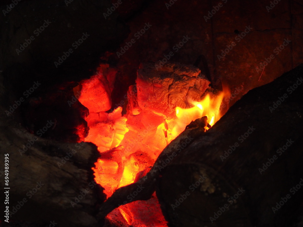 Yellow and orange flames over the embers of a winter bonfire Yellow and orange flames over the embers of a winter bonfire