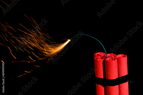 A bundle of dynamite with lit fuse again black background
