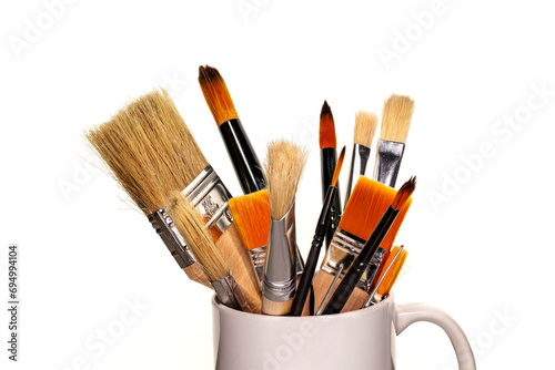 Brushes of different kinds and colors in a vertical position on a white background.