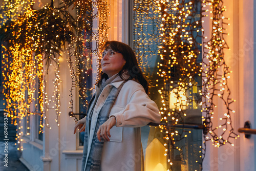 A smiling woman enjoying the charm of a Nordic small town with a new year decorations. photo