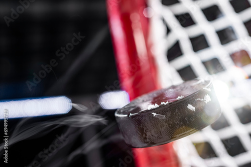 An ice hockey puck flying mid-air as it as it scores a goal