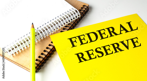 FEDERAL RESERVE text written on a yellow paper with notebook photo