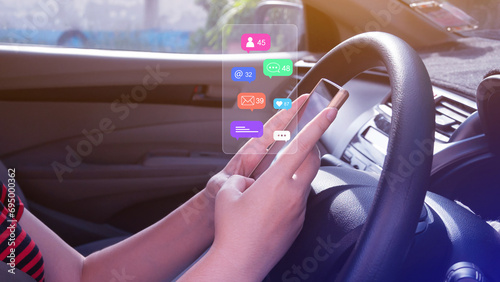 Woman using social media and digital online marketing concepts on mobile phones with icons such as notifications, messages, comments on the smartphone screen in a car. © rawintanpin