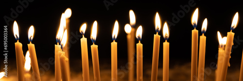 Many burning candles in the church, web banner