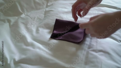 Groom puts on a handkerchief. A girl, a bride or bridesmaid, straightens cloth on a man's suit. Male in a white shirt, tie and jacket. photo