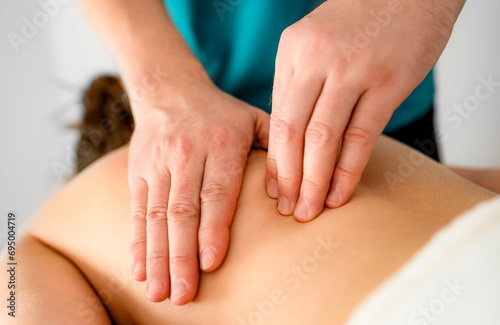 Massage therapist doing massage of trigger points in the back