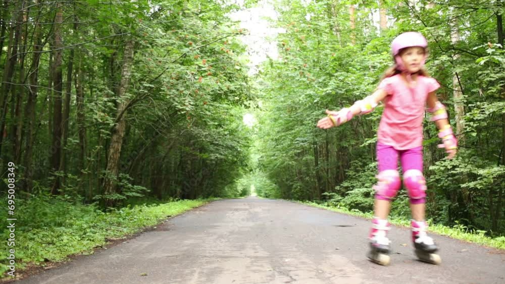 Happy girl in pink roller skate on road in summer park Happy girl in pink roller skate on road in summer park