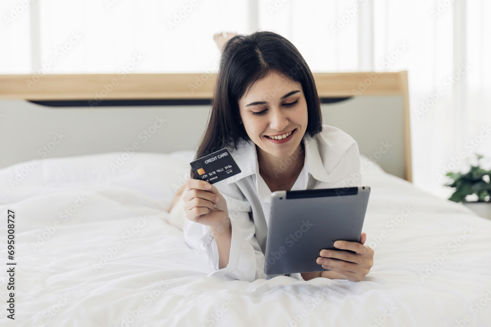 Happy woman online shopping on bedroom at home. woman relax on bed at home texting messaging on smartphone, smiling girl use cellphone, shopping online from home Happy woman online shopping on bedroom at home. woman relax on bed at home texting messaging on smartphone, smiling girl use cellphone, shopping online from home