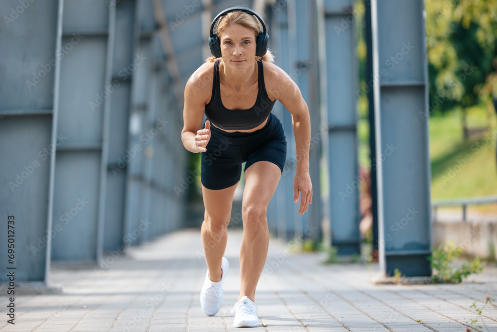 Woman getting ready for running and enjoying music in headphones.