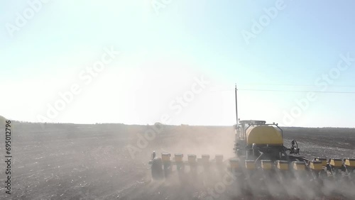 Green tractor planting corn in Ukraine photo