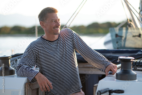 Smiling man in a striped thsirt on ayacht photo