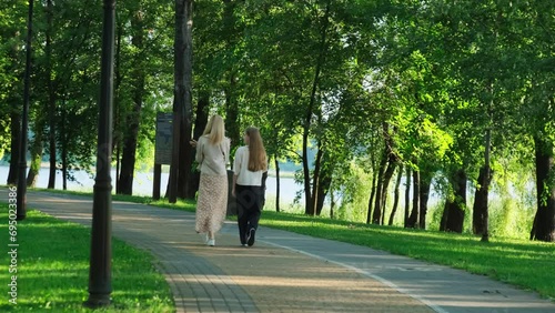 Wallpaper Mural Pleased mother spends free day with daughter strolling in park. Young woman endeavors dedicating time to teenager in nature Torontodigital.ca