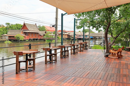 View of wooden stylish outdoor waterside cafe with couple seat design idea. Wooden tables and chairs simplistic. Empty restaurant cafe.